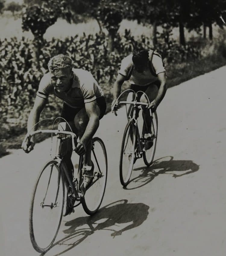 並木道を走る2人のロードレーサーの古い写真