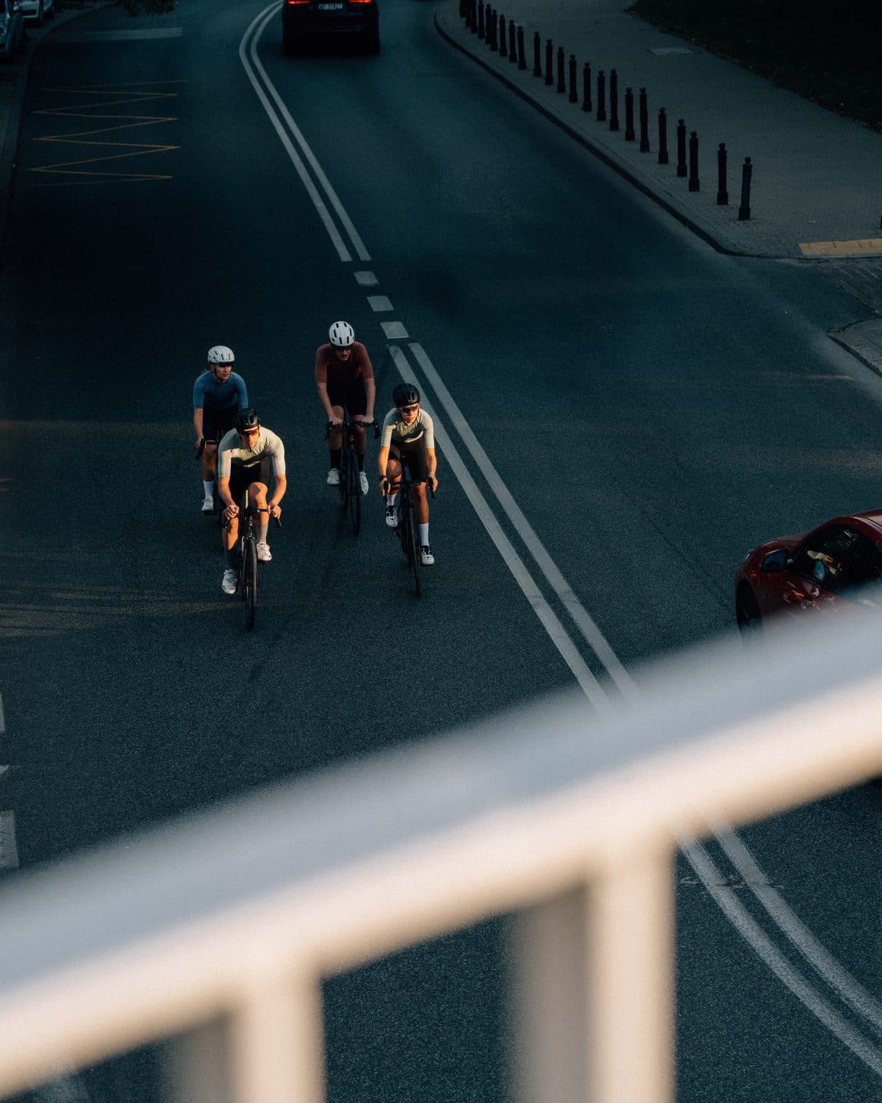 夕方の道路をロードバイクで走る4人