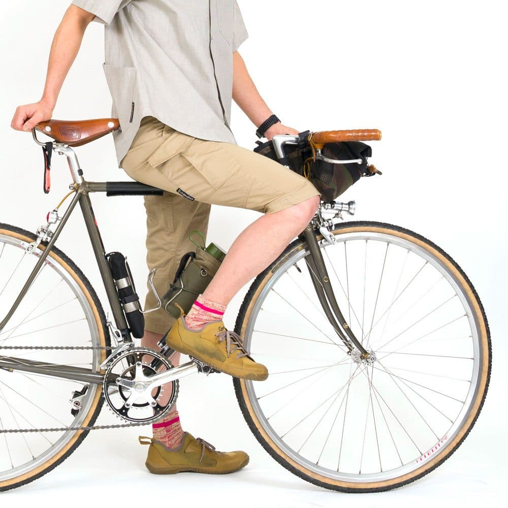 ベージュの7分丈パンツで自転車にまたがる人