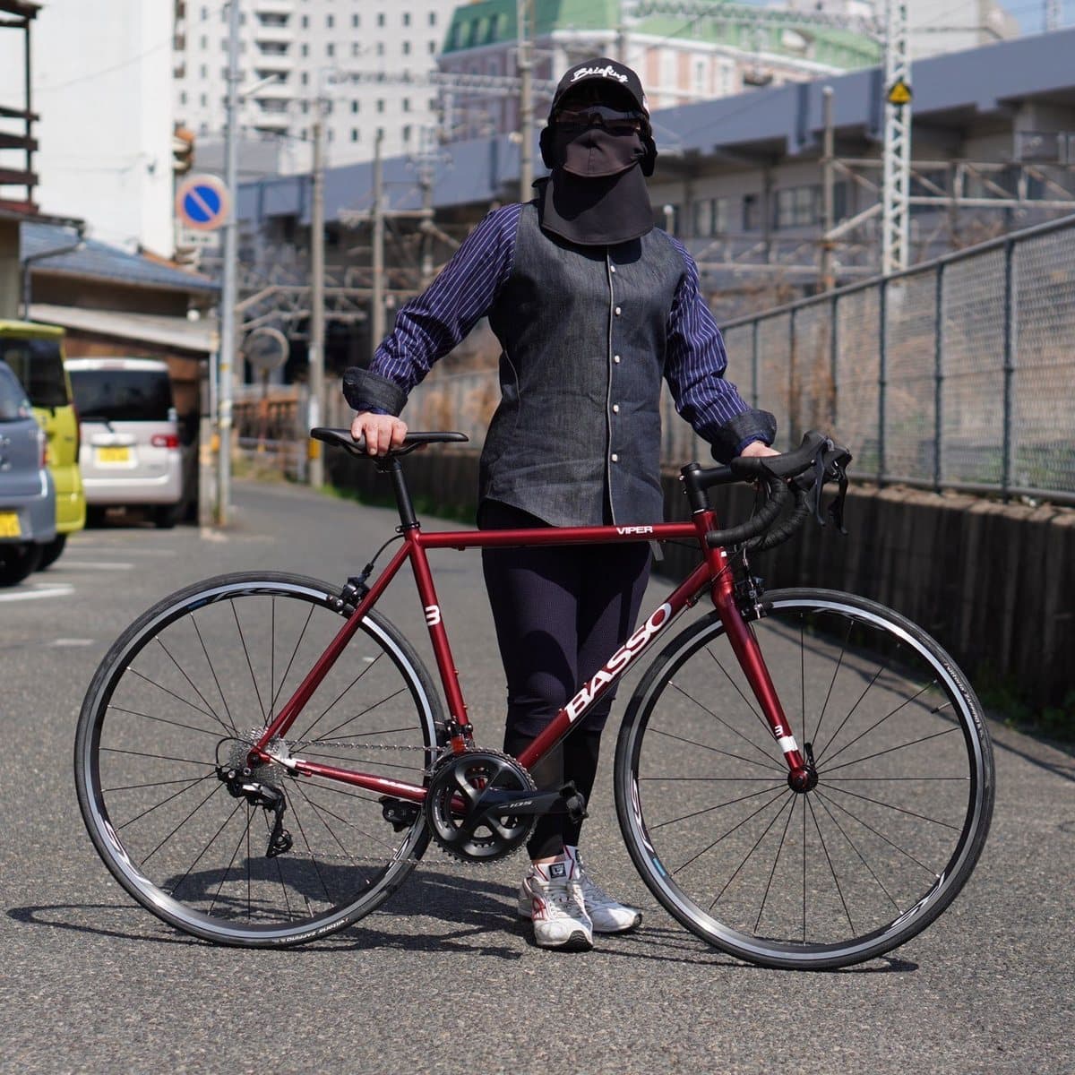 cycleZオリジナルのデニムシャツを着てロードバイクの横に立つ女性の正面全身